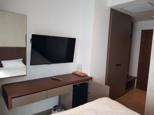 a room with a desk with a television on the wall at MY HOTEL in Prizren