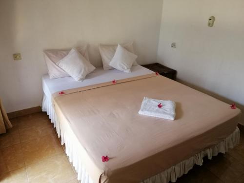 a bedroom with a large bed with pink flowers on it at Vacation Inn Gili in Gili Trawangan