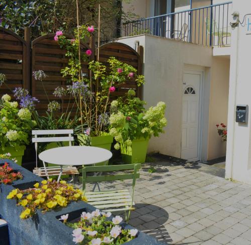a patio with a table and chairs and flowers at Logis Hotel Epi d'Or in Angoulême