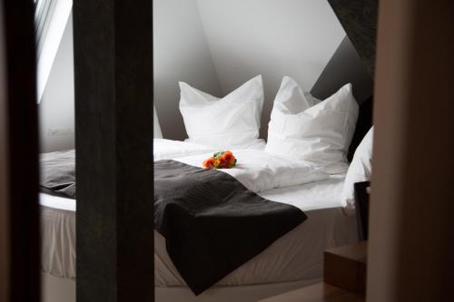 a bed with white pillows and a flower on it at Alpha & Omega Hotel in Stuttgart