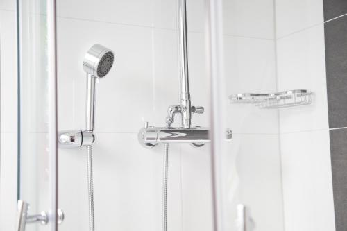 a shower with a shower head in a bathroom at Alpha & Omega Hotel in Stuttgart