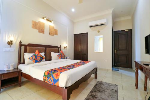 a bedroom with a large bed and a television at FabHotel K9 Villa in Ludhiana