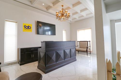 a living room with a black fireplace and a chandelier at FabHotel K9 Villa in Ludhiana