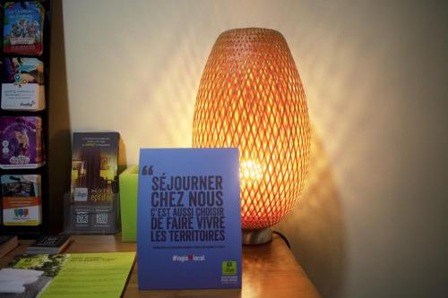 a lamp sitting on a table next to a book at Logis Hotel Epi d'Or in Angoulême