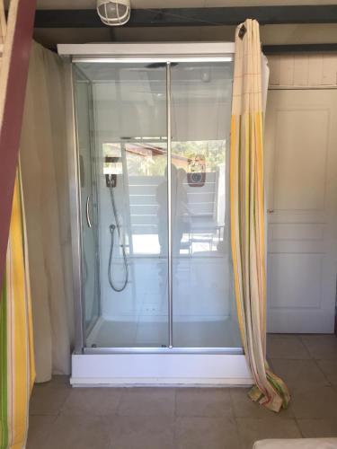 a sliding glass shower door in a room with at un nid en provence in Coudoux