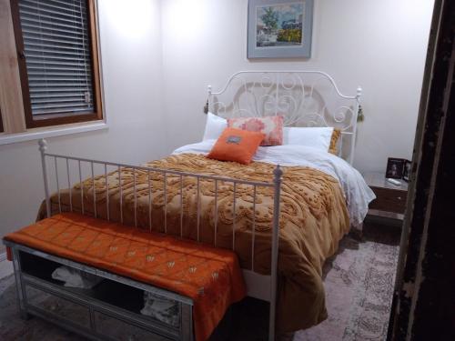 a bedroom with a bed with an orange pillow on it at Peaceful, Convenient and Luxurious in Phillip