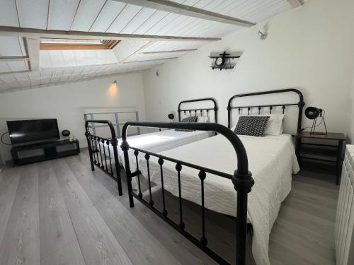 a bedroom with a black bed and a television at T3 COSY MAISON DE VILLE TERRASSE AU CALME in Rochefort