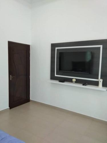 a flat screen tv on a wall next to a door at Captain's Cabin Resort - Naval Heritage (Swimming Pool) in Kota Bharu