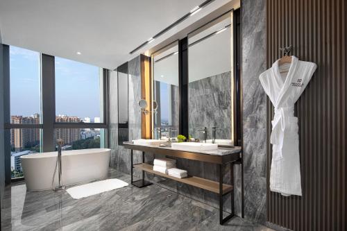 La salle de bains est pourvue d'une baignoire, d'un lavabo et d'une baignoire. dans l'établissement Wanda Jin Xiangjiang Dingzhou, à Dingzhou