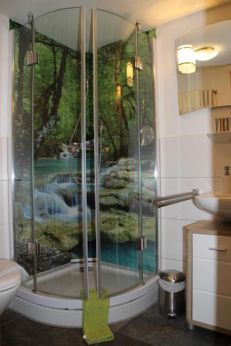 een badkamer met een douche en een schilderij aan de muur bij Haus & Heim Ferienwohnung in Oberstdorf