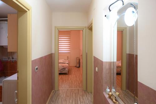 a hallway with a mirror and a room with two beds at MB Apartments in Jagodina