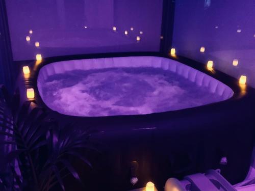 a purple bath tub with lights in a room at Luxury 9ine PENTHOUSE WITH GARDEN & JACUZZI in Birmingham