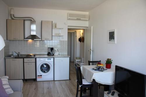 a kitchen and living room with a table and a washing machine at Studio Tamara in Dubrovnik