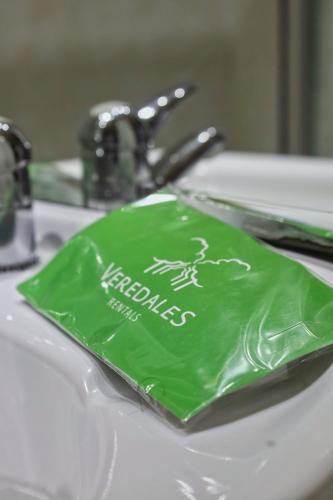 a green plastic bag sitting on a bathroom sink at Parque del Sella in Arriondas