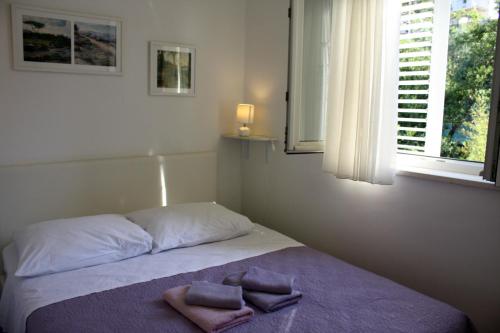 a bedroom with a bed with two towels on it at Studio Tamara in Dubrovnik