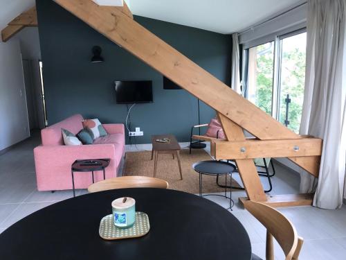 a living room with a pink couch and a table at Les 4 gites de la Saisse in Pont-de-Poitte
