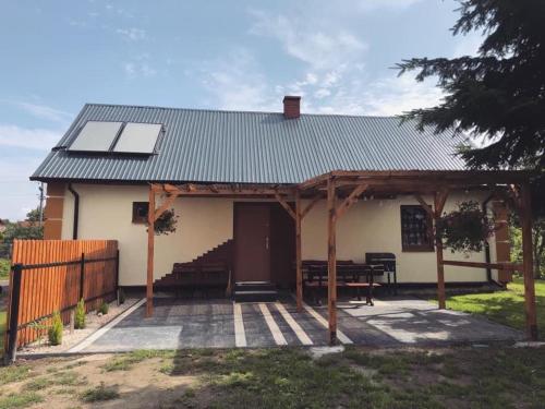 a house with a solar roof and a patio at Domek Zuza Nielisz in Nielisz