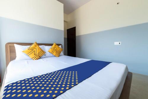 a bedroom with a blue and white bed with yellow pillows at Sri Annapurneshwari Residency & Lodging in Hassan