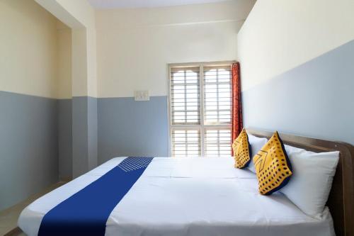 a bedroom with a bed with two pillows on it at Sri Annapurneshwari Residency & Lodging in Hassan
