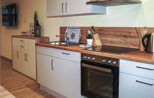 a kitchen with a sink and a stove at Lovely Home In Gützkow With Kitchen in Gützkow