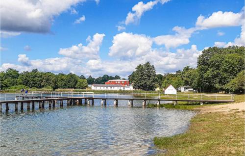 a bridge over a lake with a building in the background at Lovely Home In Gützkow With Kitchen in Gützkow