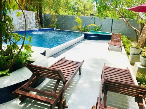 a patio with two chairs and a swimming pool at Bangalawa Resort in Habarana
