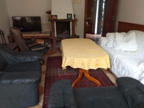 a living room with a table and a couch at ZACISZNY DOMEK Z OGRODEM NAD MORZEM in Rowy