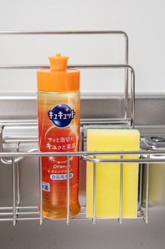 a shelf with a bottle of sauce and towels at T・Kスクエア鹿児島中央 in Kagoshima