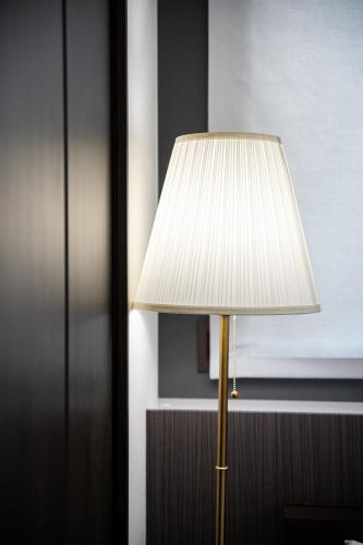 a lamp with a white shade in a room at T・Kスクエア鹿児島中央 in Kagoshima