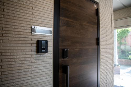 a wooden door in a brick wall at T・Kスクエア鹿児島中央 in Kagoshima