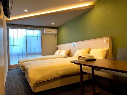 a hotel room with two beds and a table at Gion Shirakawa - Vacation STAY 24781v in Kyoto