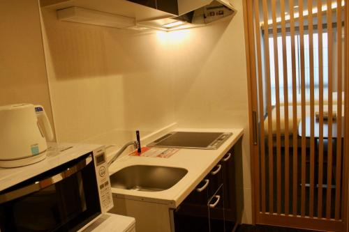 a small kitchen with a sink and a microwave at Gion Shirakawa - Vacation STAY 24781v in Kyoto