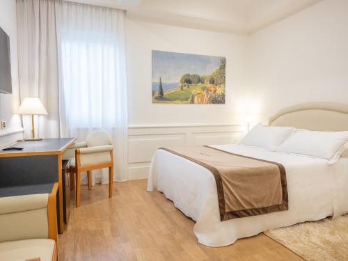 a hotel room with a bed and a desk at Mirabella Hotel in Mirabella Eclano