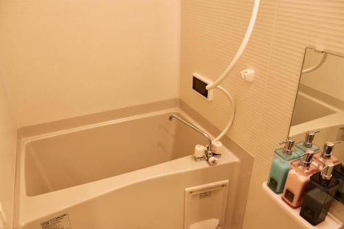 a bathroom with a tub and a toilet and a mirror at Gion Shirakawa - Vacation STAY 24783v in Kyoto