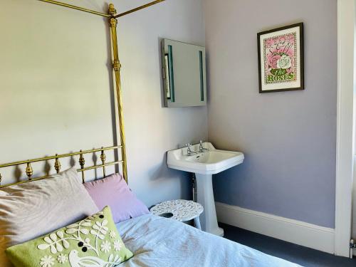 a bedroom with a bed and a sink and a mirror at Beautiful Private 2 Bedroom Suite in Mansion Home with Free Parking in Brighton & Hove