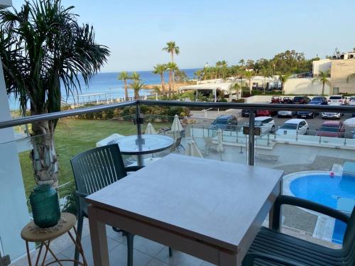 a table and chairs on a balcony with a view of the ocean at Coralli Superior Seaview in Protaras