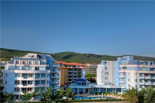 een groep appartementsgebouwen met bergen op de achtergrond bij PMG Laguna Apartments in Sunny Beach