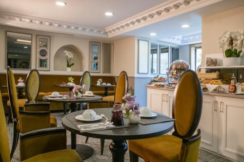a dining room with two tables and chairs at Hôtel Petit Palais in Nice