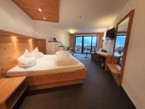 a hotel room with a bed and a desk and a desk at Hotel Klockerhof in Lermoos
