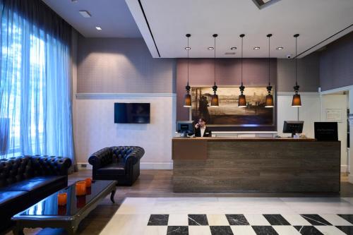 a lobby with a waiting area with chairs and a counter at Catalonia Passeig de Gràcia 4* Sup in Barcelona