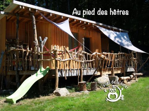 a slide in front of a building with a house at Gîte nature Au pied des hêtres in Vitrac-sur-Montane