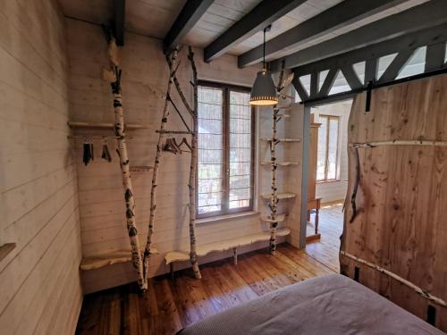 een kamer met houten wanden, een bed en ramen bij Gîte nature Au pied des hêtres in Vitrac-sur-Montane