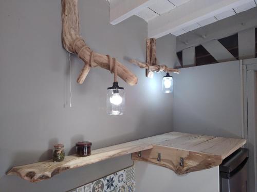 a kitchen with a wooden counter and two lights at Gîte nature Au pied des hêtres in Vitrac-sur-Montane