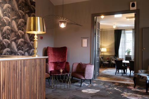 a living room with a chair and a table at Elite Stadshotellet Västerås in Västerås