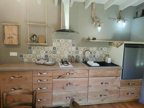 a kitchen with a wooden dresser with a stove at Gîte nature Au pied des hêtres in Vitrac-sur-Montane