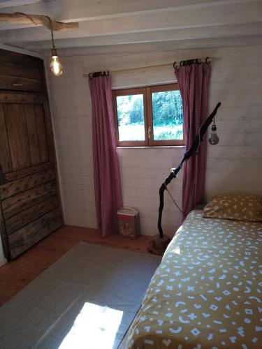 a bedroom with a bed and a window in a room at Gîte nature Au pied des hêtres in Vitrac-sur-Montane