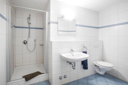uma casa de banho com um lavatório, um chuveiro e um WC. em Landgasthof Krone em Offingen