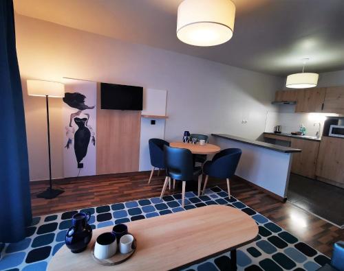 une chambre avec une table et des chaises ainsi qu'une cuisine dans l'établissement Residhome Asnieres, à Asnières-sur-Seine