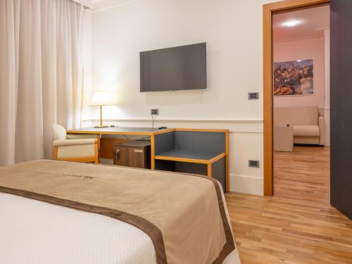 a hotel room with a bed and a desk and a television at Mirabella Hotel in Mirabella Eclano