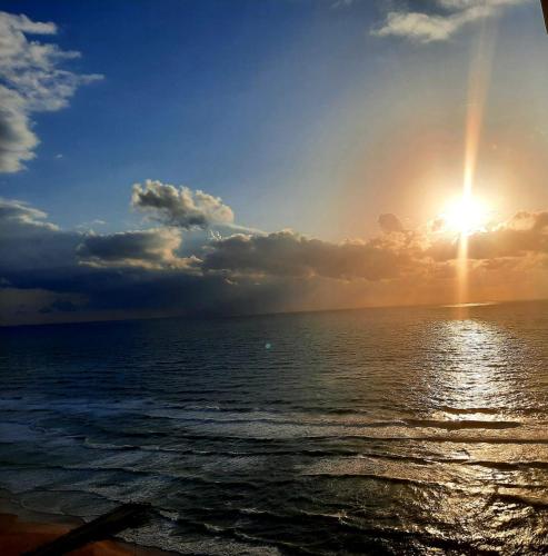 a sunset over the ocean with the sun in the sky at Sea View Deluxe in Bat Yam